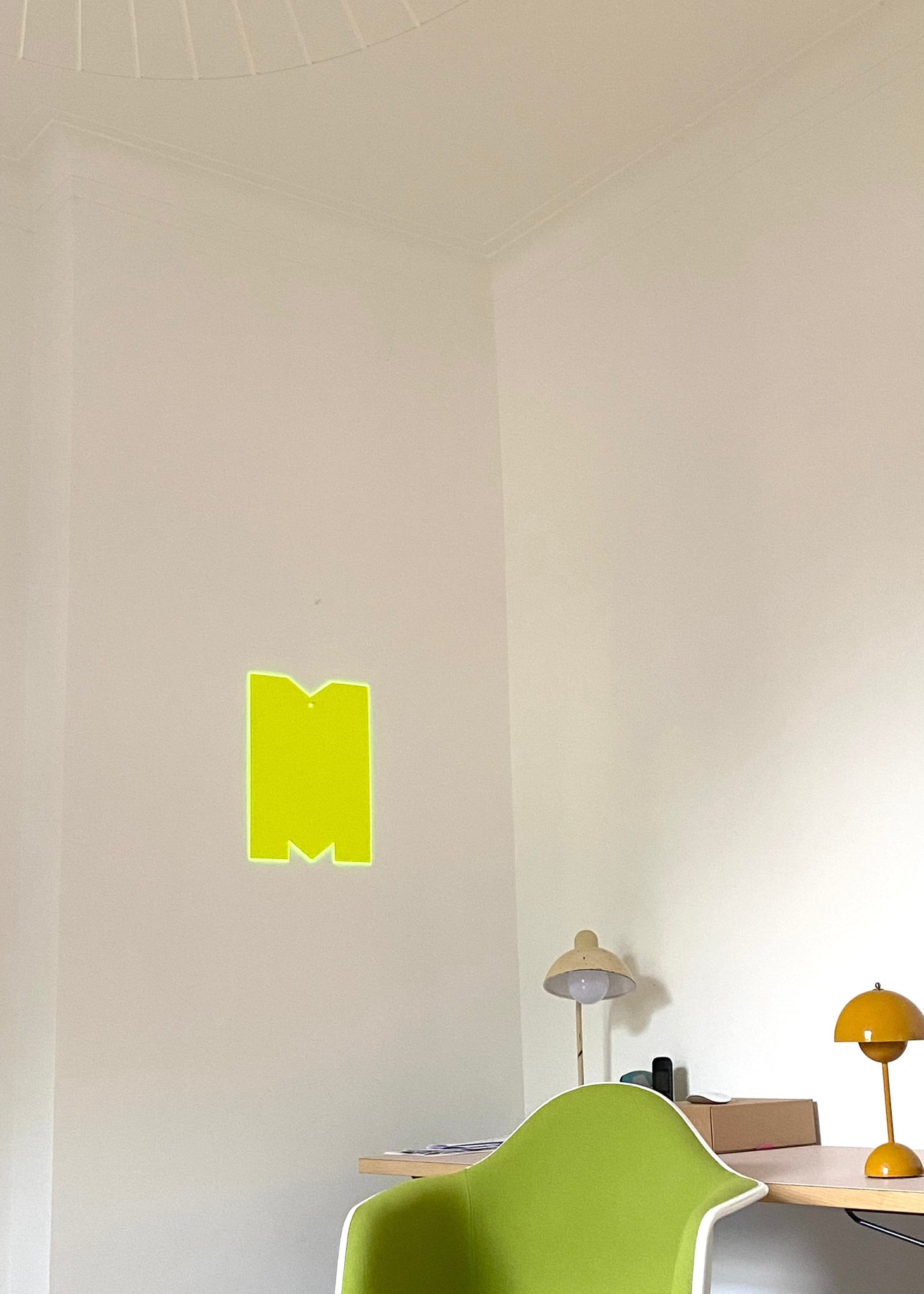 Big single letter M in neon yellow floureszierend