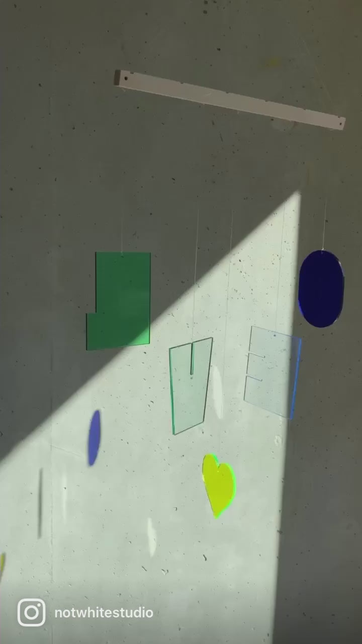 Nachhaltiges Mobilé-Set HOLA aus recyceltem Acrylglas. Fünf farbige Buchstaben mit fluoreszierenden Kanten schaffen lebendige Lichtspiele. Inklusive robuster Nylonschnur und naturbelassenem Buchenholz. Individuell arrangierbar für kreative Deko. Lieferung in nachhaltigem Geschenkkarton.